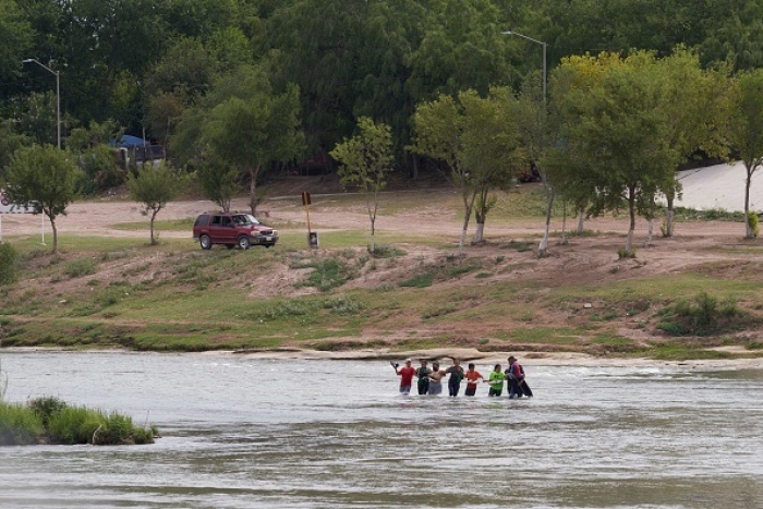 Migrants illegally cross the Rio Grande River in Eagle Pass, Texas, on May 22, 2022. (Photo by ALLISON DINNER/AFP via Getty Images)