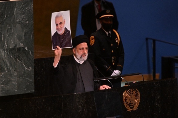 Iranian President Ebrahim Raisi holds up a photo of slain Qods Force commander Qassem Soleimani while addressing the U.N. General Assembly on Wednesday. (Photo by Ed Jones / AFP via Getty Images) 