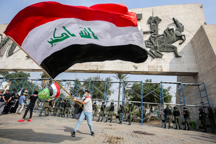 A demonstrator waves a large Iraqi national flag during an anti-government protest over corruption and poor services in Tahrir Square in the centre of Iraq's capital Baghdad on November 8, 2020.  (Getty Images)  