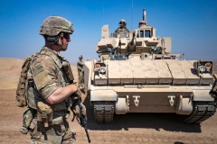 A US soldier stands near a Bradley Fighting Vehicle (BFV) during a joint military exercise between forces of the US-led &quot;Combined Joint Task Force-Operation Inherent Resolve&quot; coalition against the Islamic State (IS) group and members of the Syrian Democratic Forces (SDF) in the countryside of the town of al-Malikiya (Derik in Kurdish) in Syria's northeastern Hasakah province on September 7, 2022. (Photo by DELIL SOULEIMAN/AFP via Getty Images)